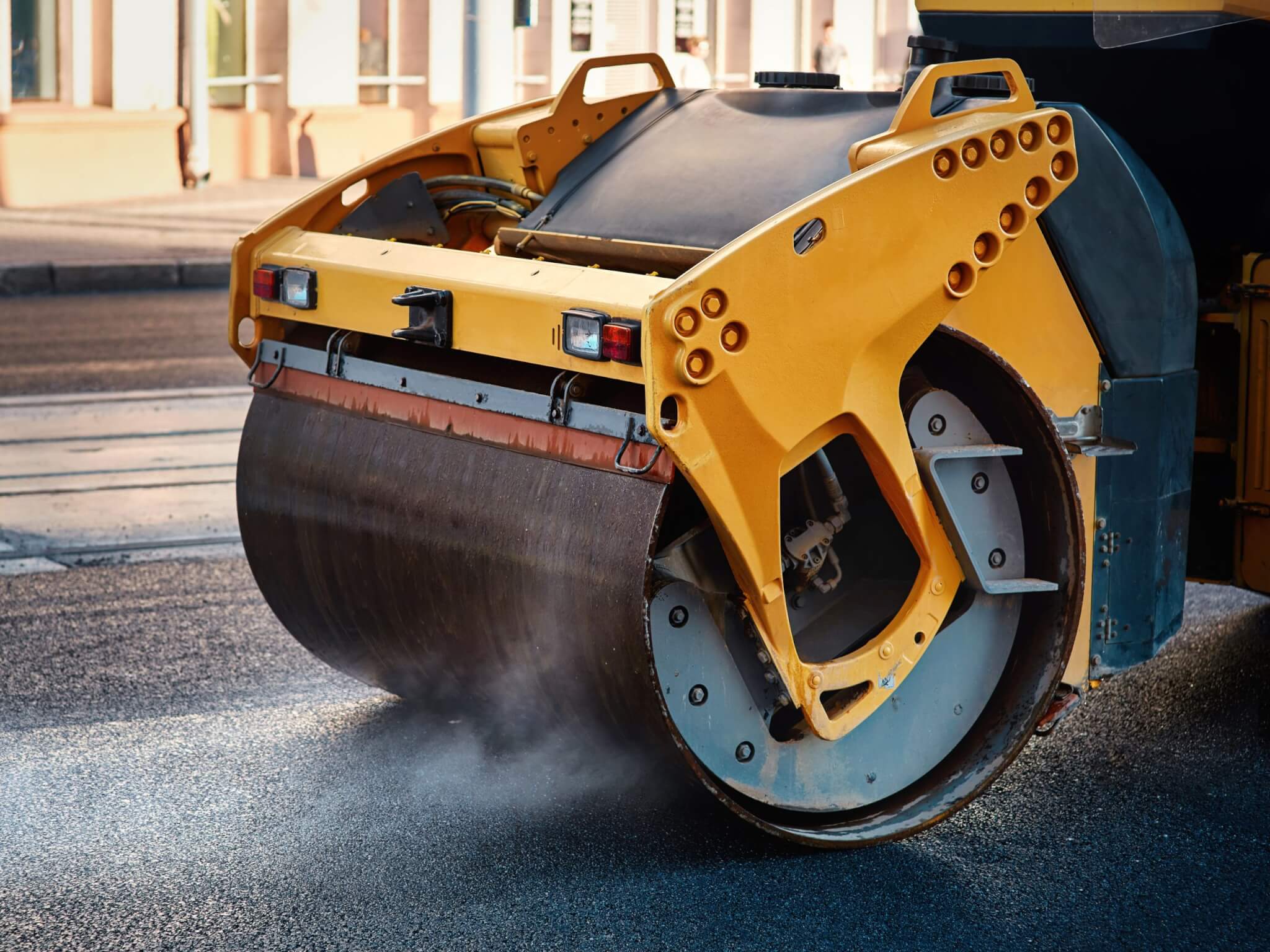 Modern heavy asphalt roller that stack and press hot asphalt in an asphalt driveway.